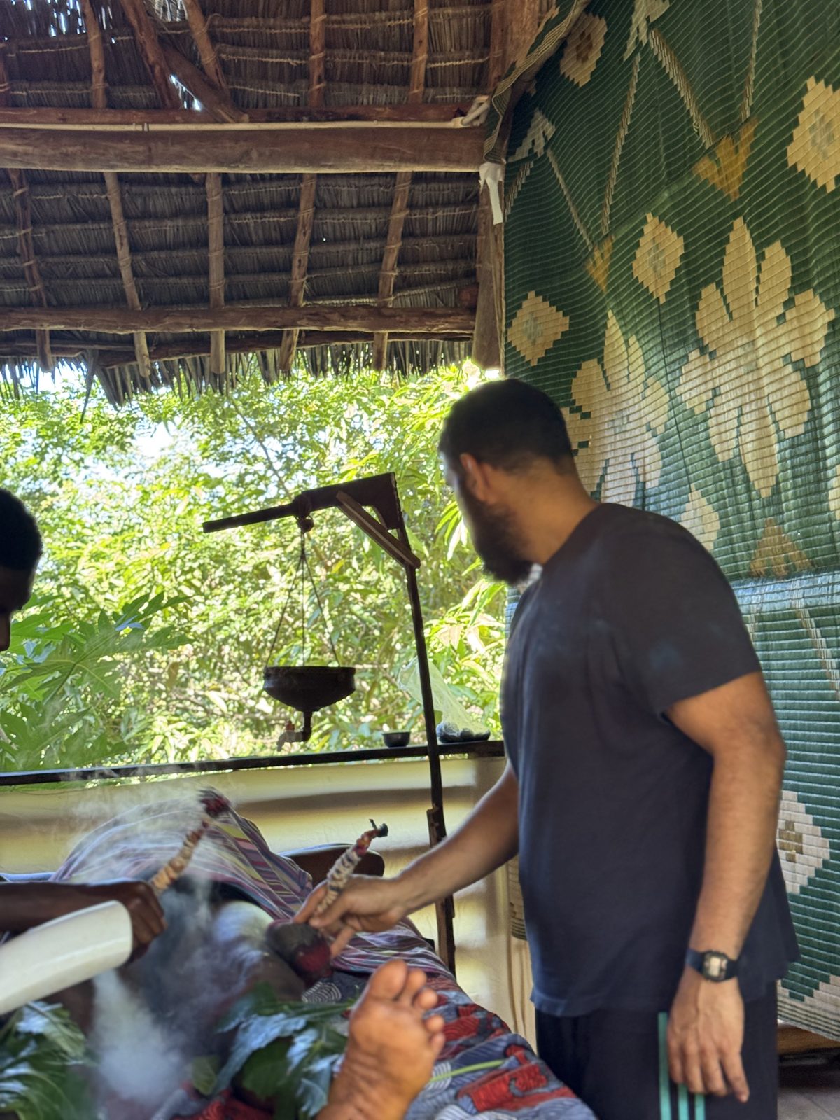 The potli treatment room — woven mats, thatched roof, and the herb-warming stand