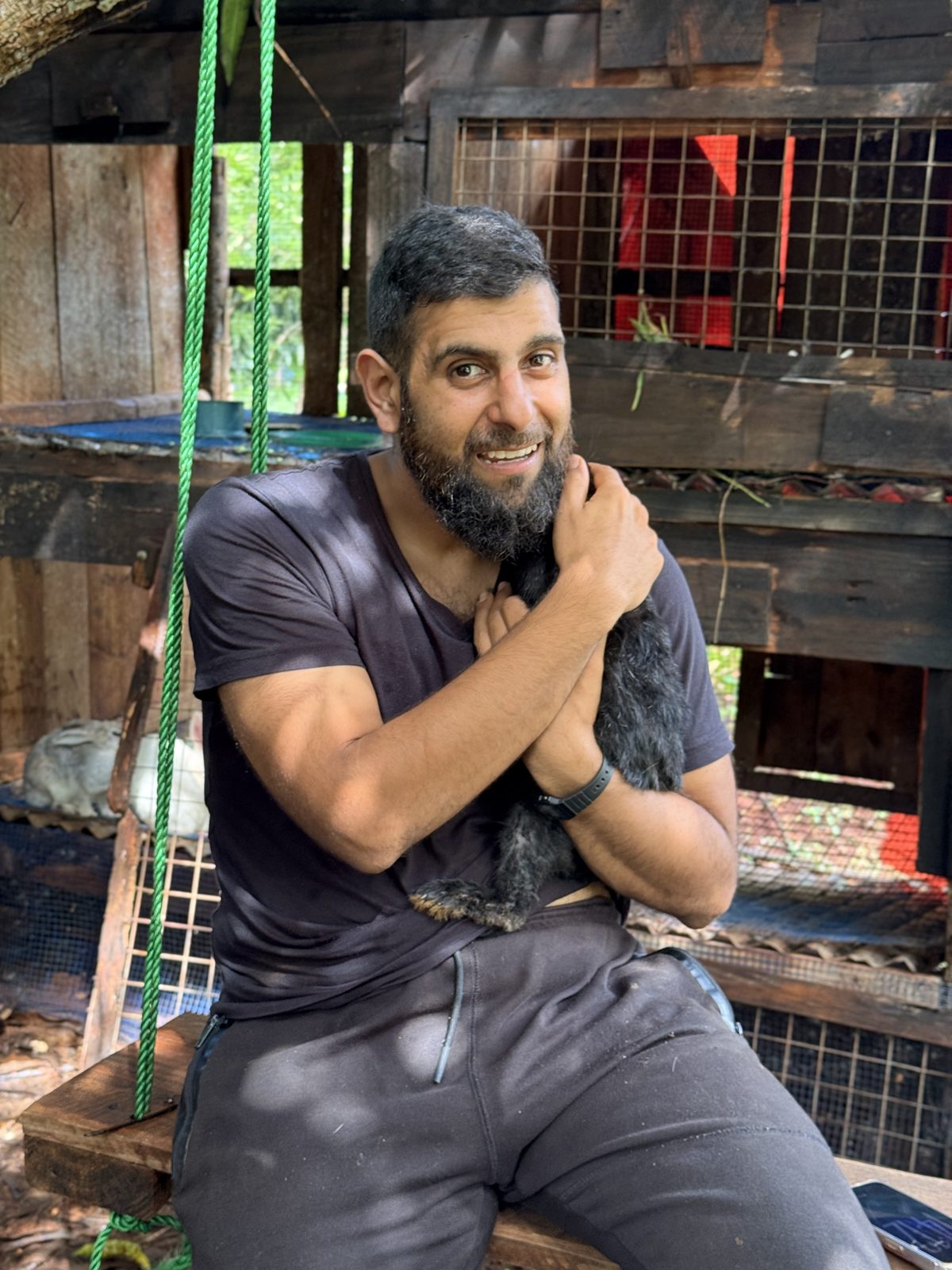 Ali holding one of the rabbits beside the hutch